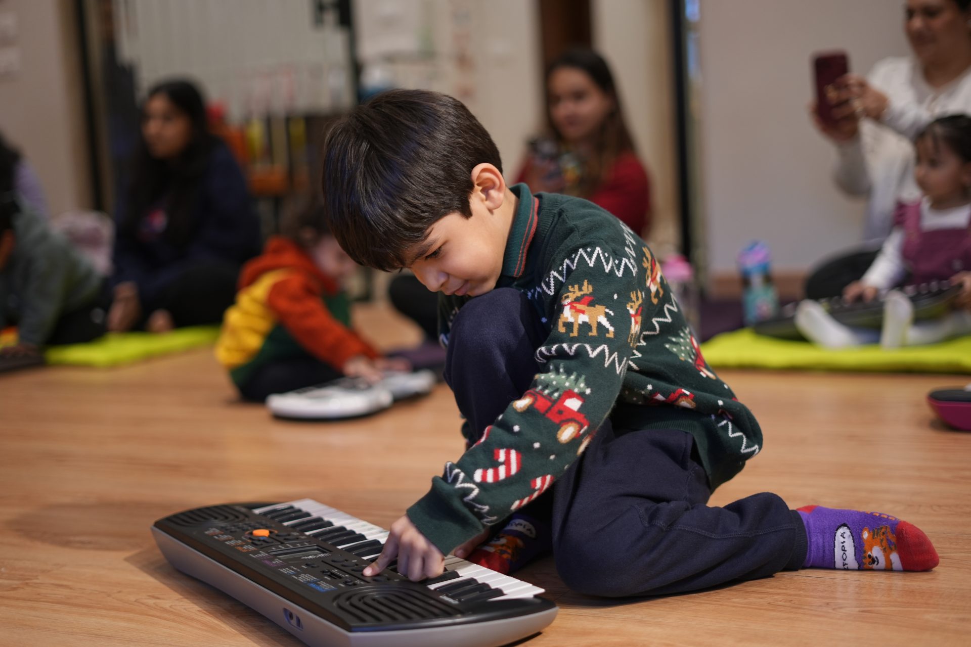 Children participating in a hands-on music activity using small instruments during a kids music class in JLT